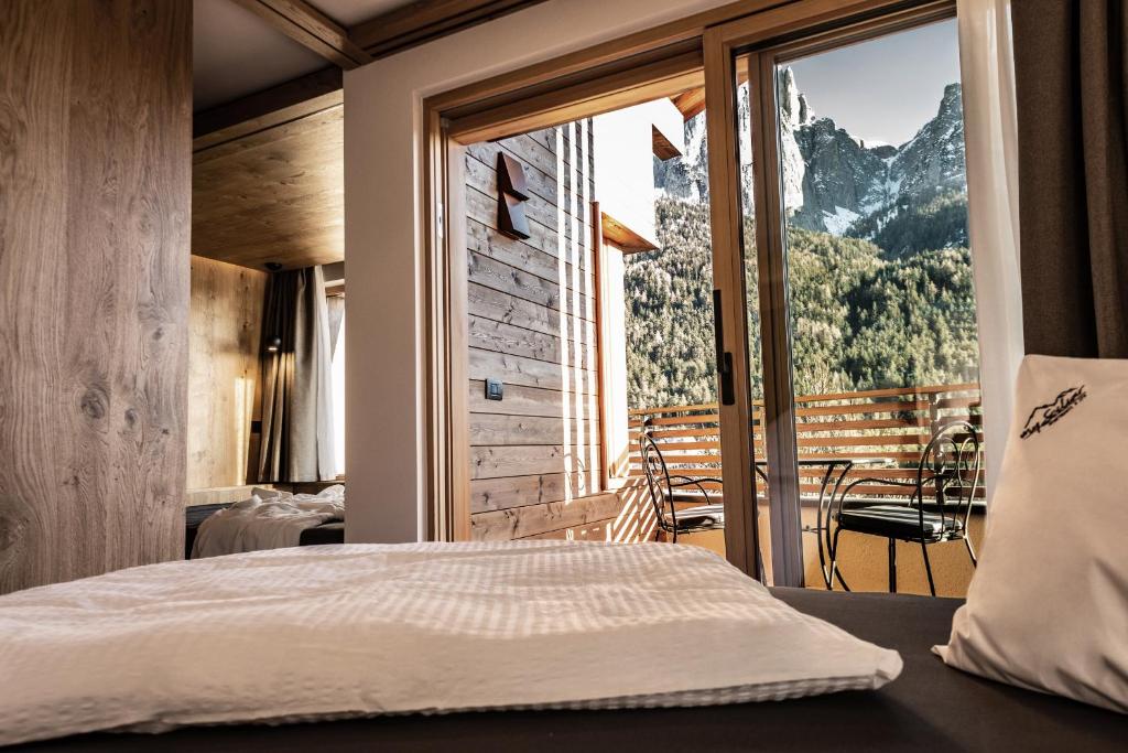 a bedroom with a bed and a view of a mountain at Mysciliar Apartment Tree I in Siusi