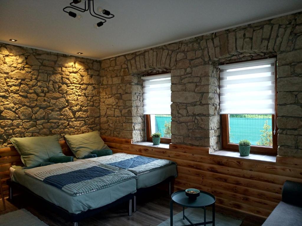 a bedroom with a bed and a stone wall at Kaland apartman 1 in Sátoraljaújhely