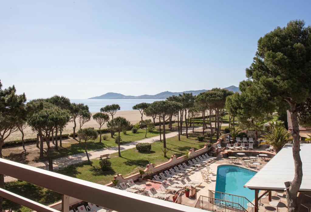 uma vista para a praia a partir da varanda de um resort em Grand Hôtel Du Lido em Argelès-sur-Mer