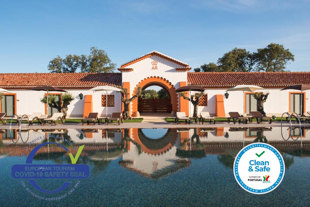 a house with a pool in front of it at Vila Gale Collection Alter Real - Resort Equestre, Conference & Spa in Alter do Chão