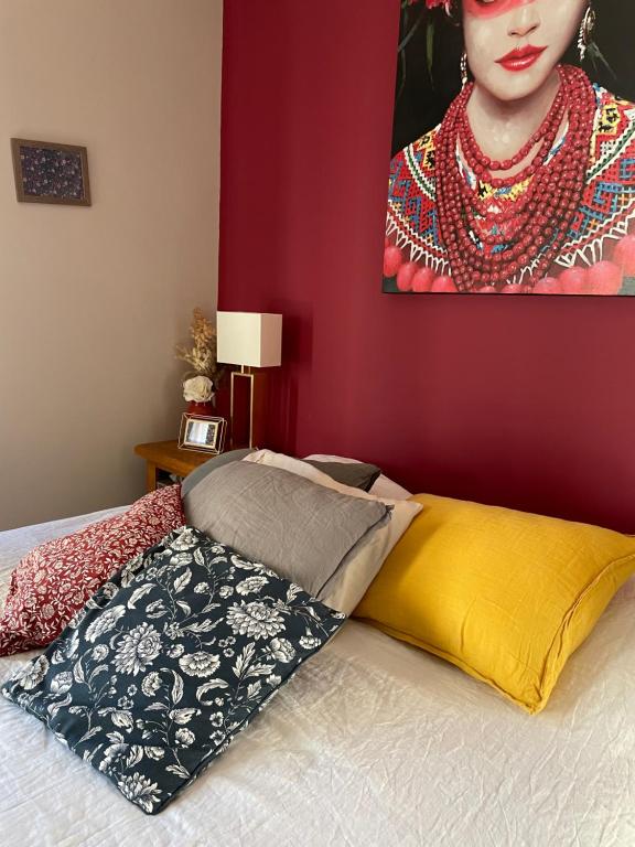 a bed with a pillow and a painting of a woman at Villa des Roses in Pontmain