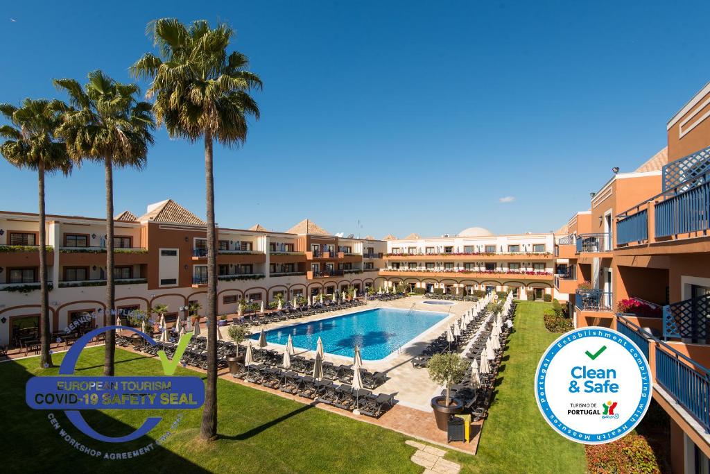 vista sulla piscina di un resort con palme di Vila Gale Tavira a Tavira