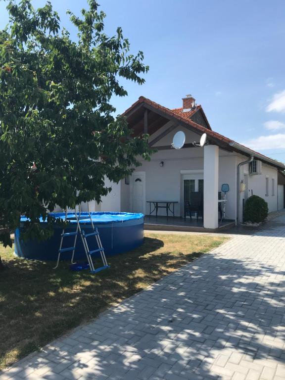 a house with a blue boat in the yard at Erika apartmanház in Gyenesdiás