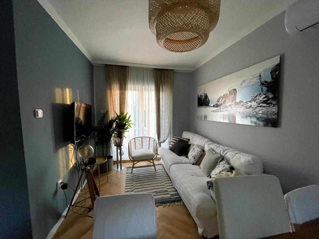 uma sala de estar com um sofá branco e cadeiras em Nyúlászó Vendégház és Galéria em Mád