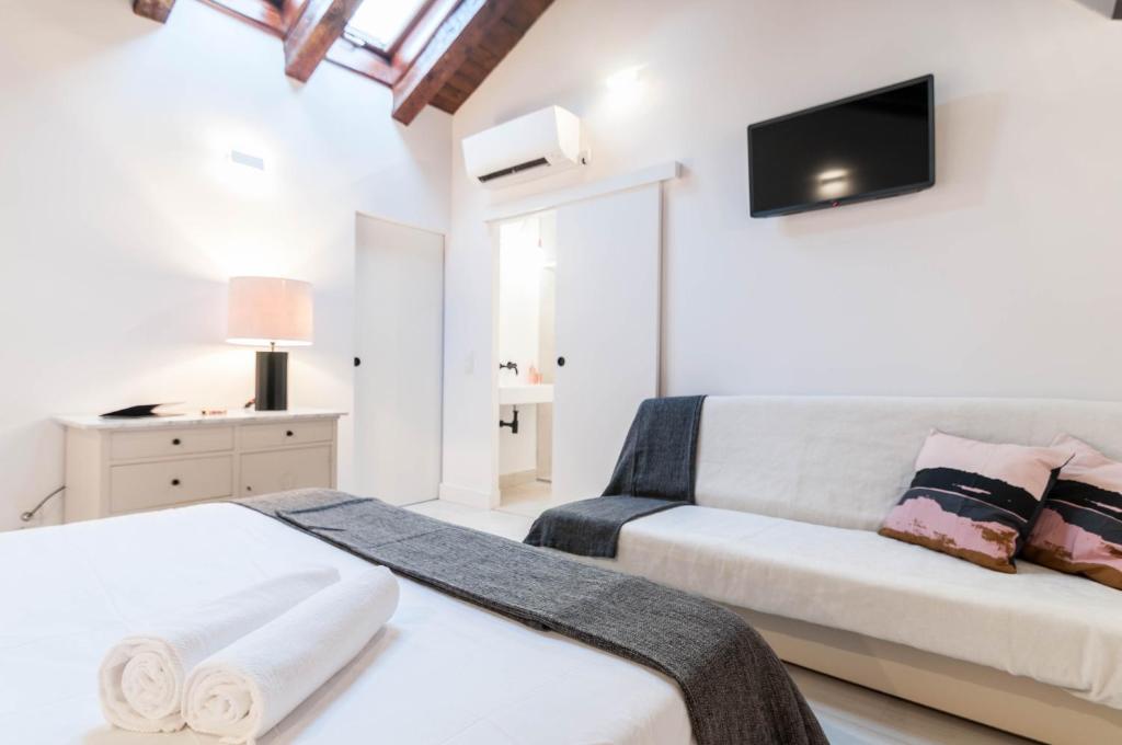 1 dormitorio con 2 camas y sofá en Hellenhost - Gran Vía, en Madrid