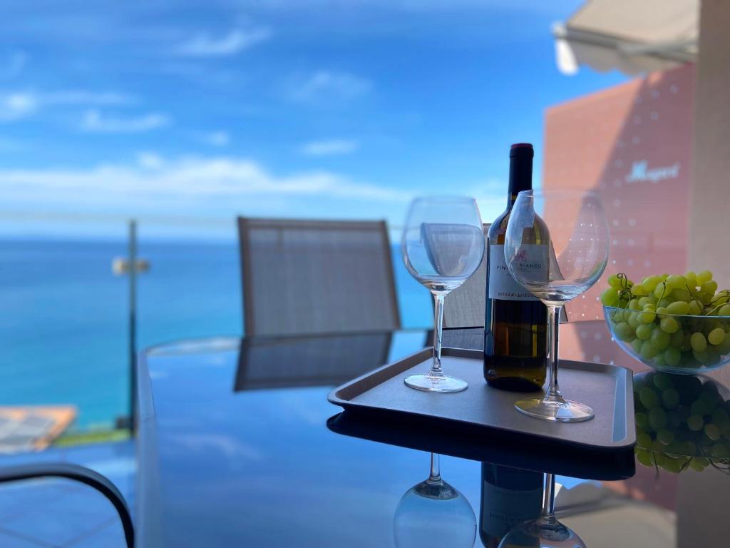a table with two glasses and a bottle of wine at Bellavista di Magarà in Cefalù
