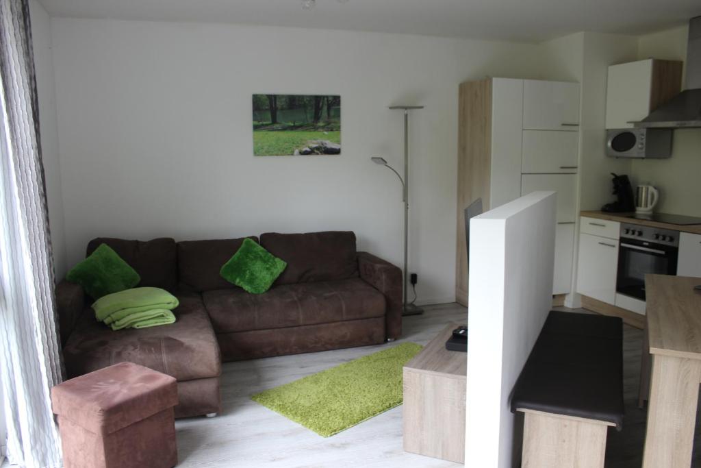 sala de estar con sofá marrón y cocina en FeWo Auszeit, en Rieden