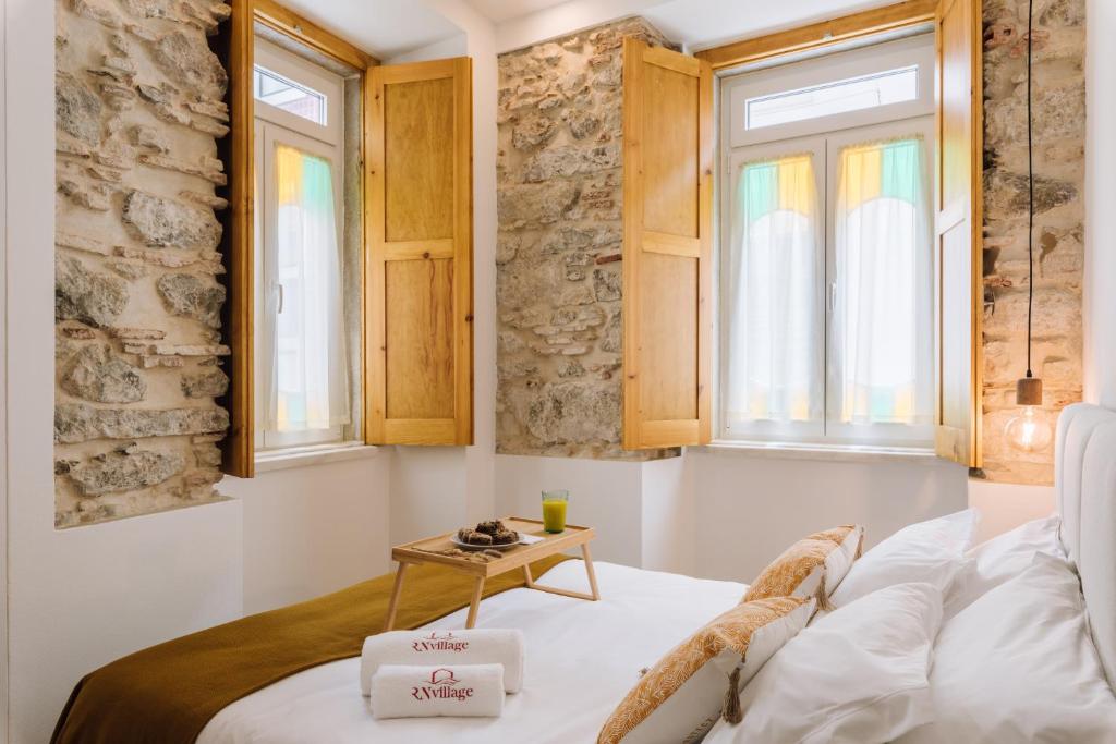 a small room with a bed and a table at Casa da Tia Zézinha by RNvillage in Sesimbra