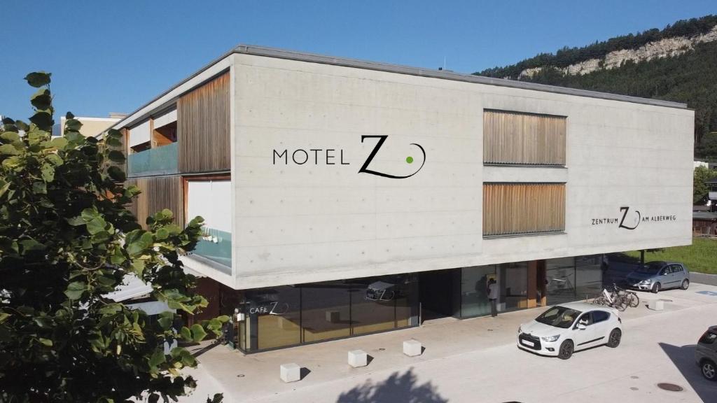 un edificio blanco con un coche aparcado delante de él en Motel Z - self checkin en Feldkirch