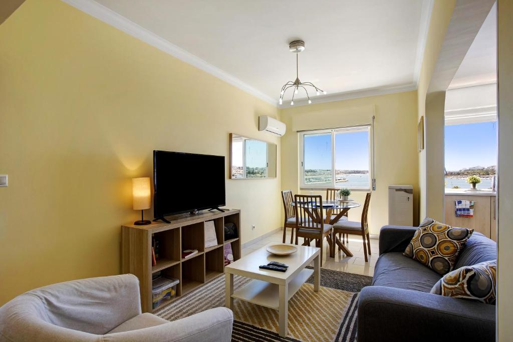 a living room with a couch and a tv at Santa Isabel Apartment in Portimão