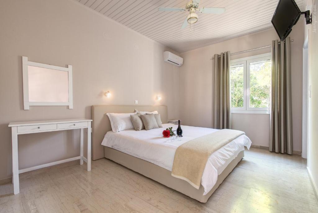 a bedroom with a white bed and a window at Paradise Village in Roda
