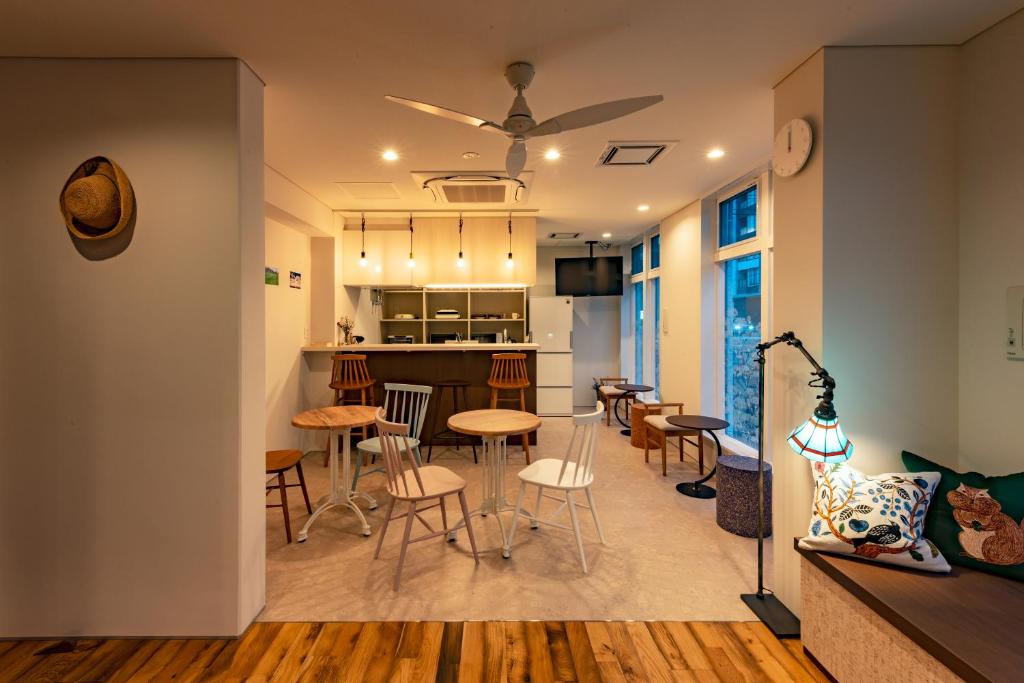 a living room and kitchen with chairs and a table at plat hostel keikyu sapporo sky in Sapporo