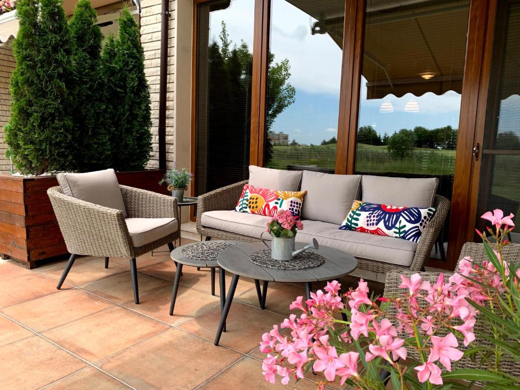 a patio with a couch and chairs and a table at Lighthouse Golf Private Villa Lake view in Balchik
