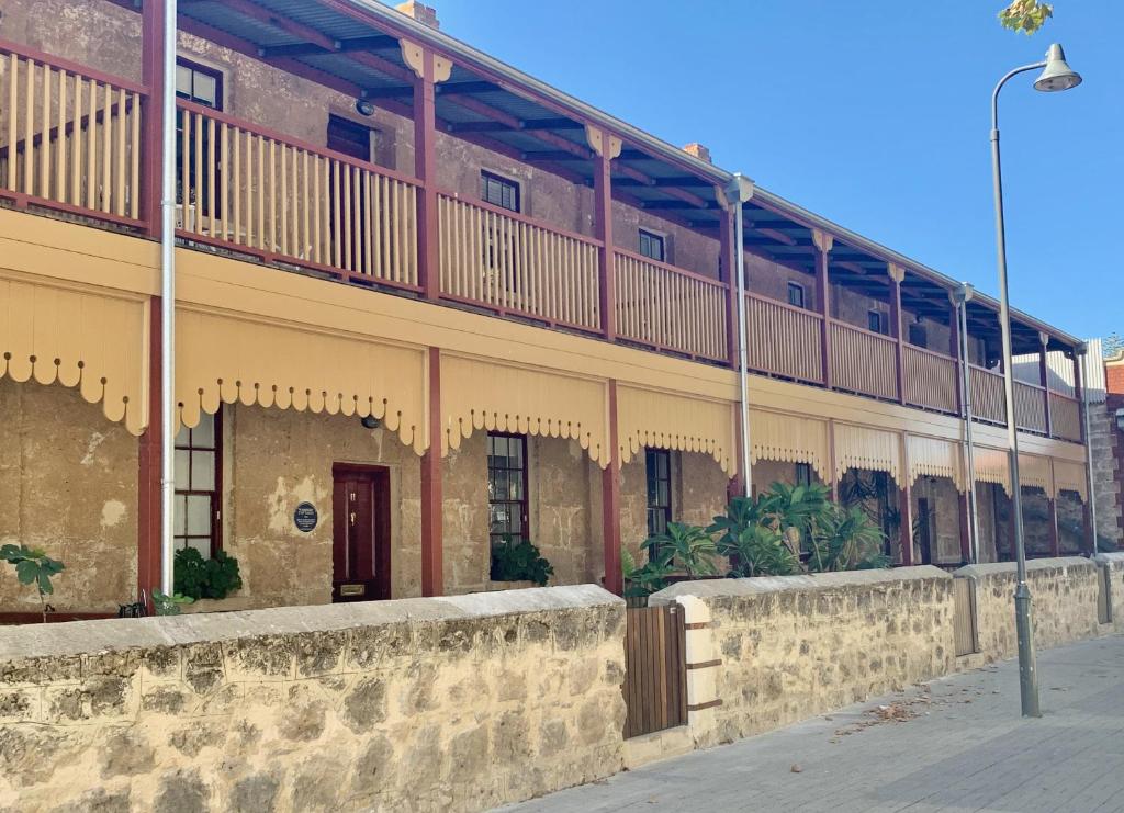 a building with a balcony on the side of it at Warders Cottage: Iconic Cottage in the Heart of Freo in Fremantle