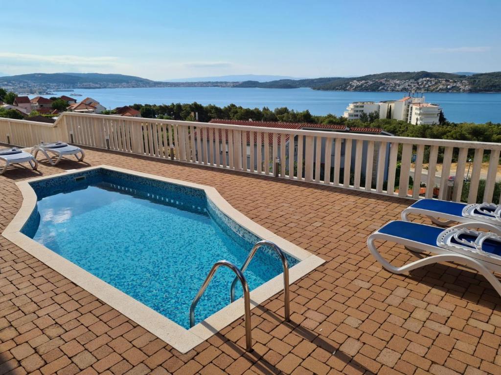 a swimming pool on a patio with a view of the water at Villa Luciana in Trogir