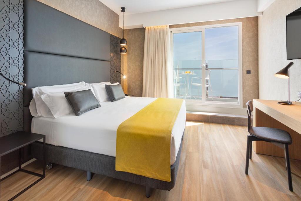 
a hotel room with a large bed and a large window at Catalonia Giralda in Seville
