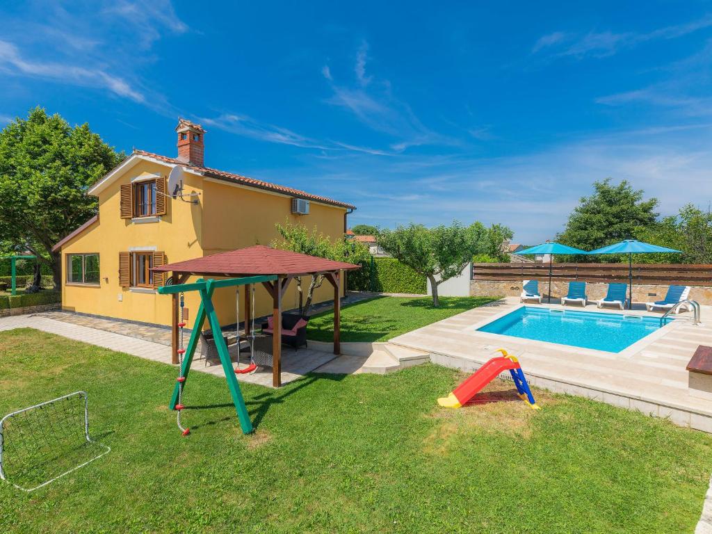 a backyard with a pool and a swing set and a house at Holiday Home Nikolina - Roj412 by Interhome in Sveti Petar u Šumi