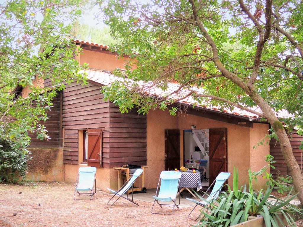 a group of chairs sitting outside of a house at Holiday Home Les maisons de la forêt by Interhome in Lacanau-Océan