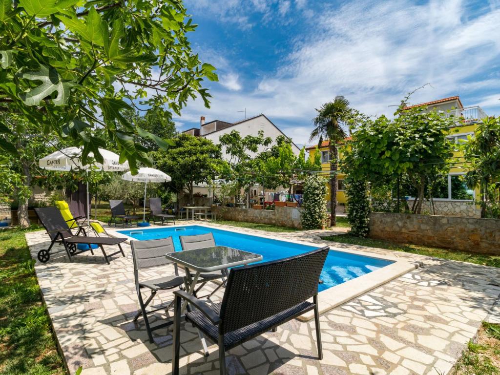 a patio with a table and chairs next to a swimming pool at Apartment Villa Sandra - PUL412 by Interhome in Vodnjan