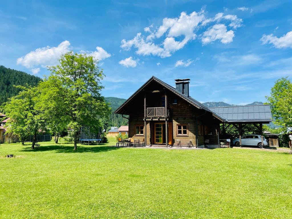 a log cabin with a large grassy yard at Haus Liesenfeld in Gosau