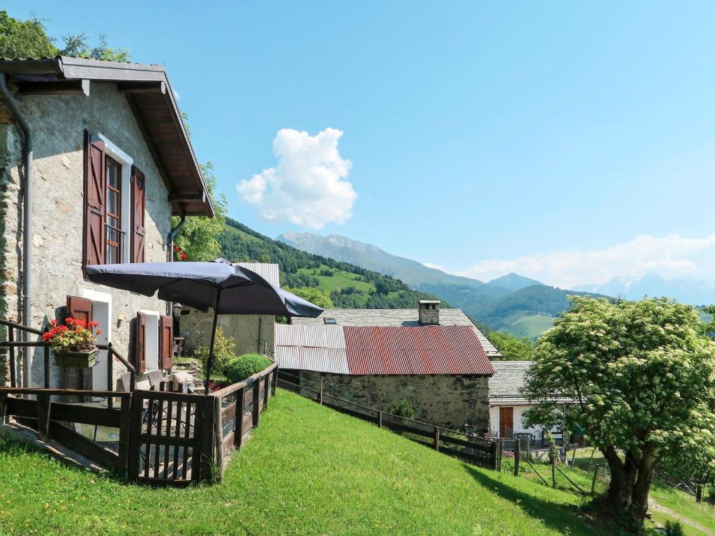 a house with an umbrella on the side of it at Apartment Baita dei Nonni-2 by Interhome in Livo