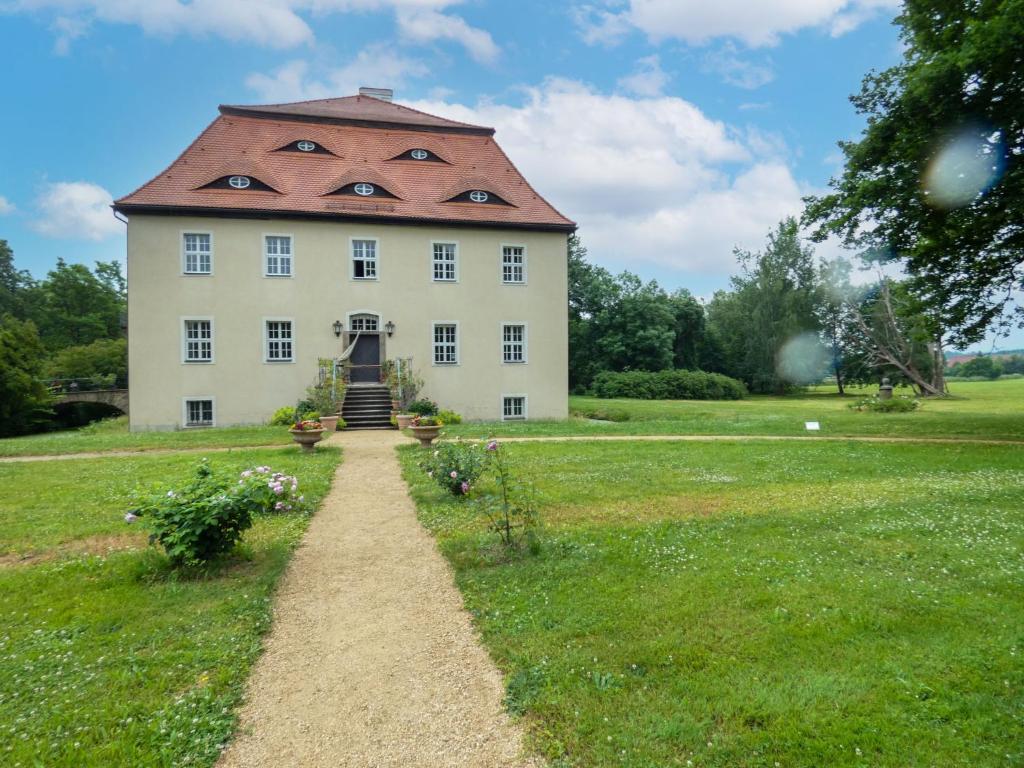 ein großes weißes Gebäude mit rotem Dach in der Unterkunft Apartment Rittergut Wurschen by Interhome in Wurschen