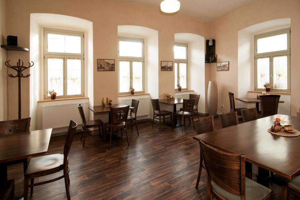 a dining room with tables and chairs and windows at Hotel Beránek in Blatná