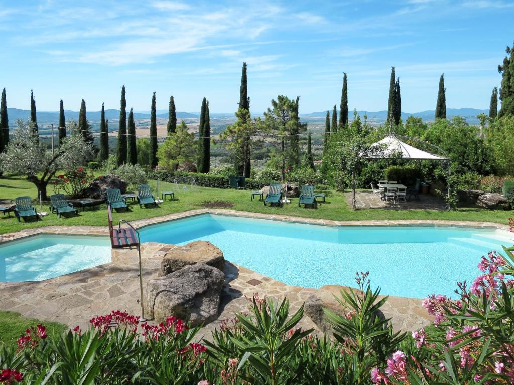 a swimming pool in a yard with trees and flowers at Apartment Loggetta by Interhome in Podere Caminino