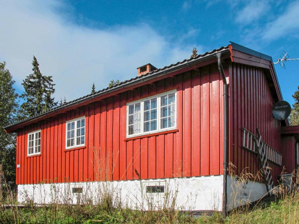 ein rot-weißes Gebäude mit zwei Fenstern in der Unterkunft Chalet Skeisvegen - OPP208 by Interhome in Svingvoll
