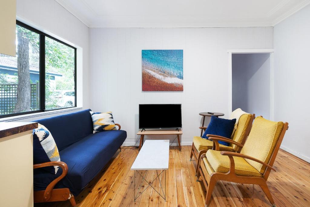 a living room with a blue couch and two chairs at Beach Shack semi detached, 2 Min Walk to Beach-Lilly Pilly in Pearl Beach