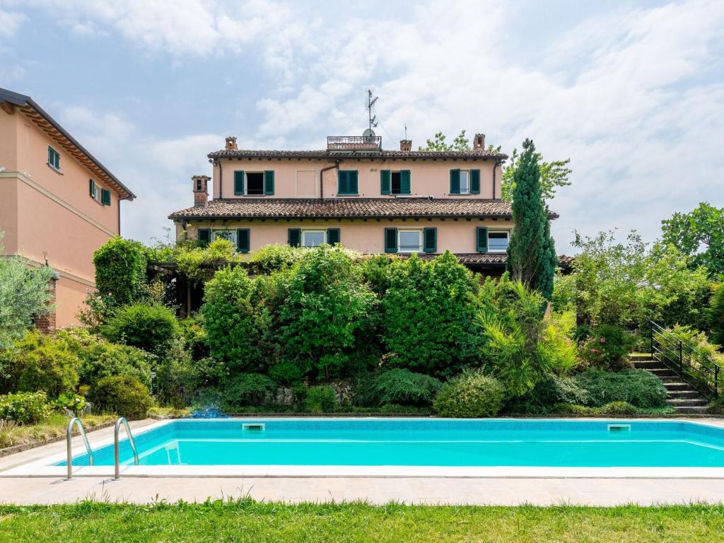 ein Haus mit einem Swimmingpool vor einem Gebäude in der Unterkunft Villa Ca' del Vento by Interhome in Montù Beccaria