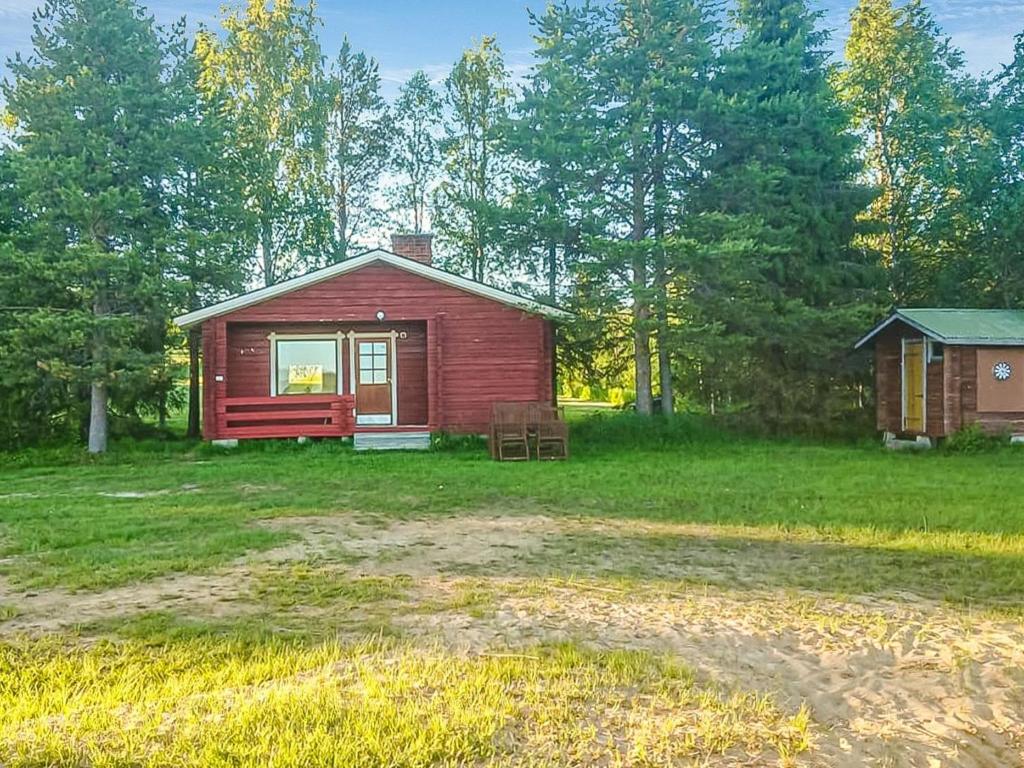 uma pequena cabine vermelha no meio de um campo em Holiday Home Parkkisenniemen lomamökit by Interhome em Karvonen