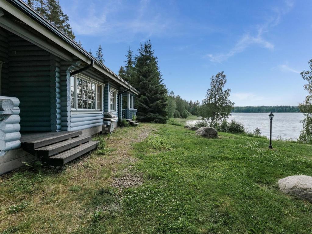 a house with a porch next to a lake at Holiday Home Iltarusko by Interhome in Hara