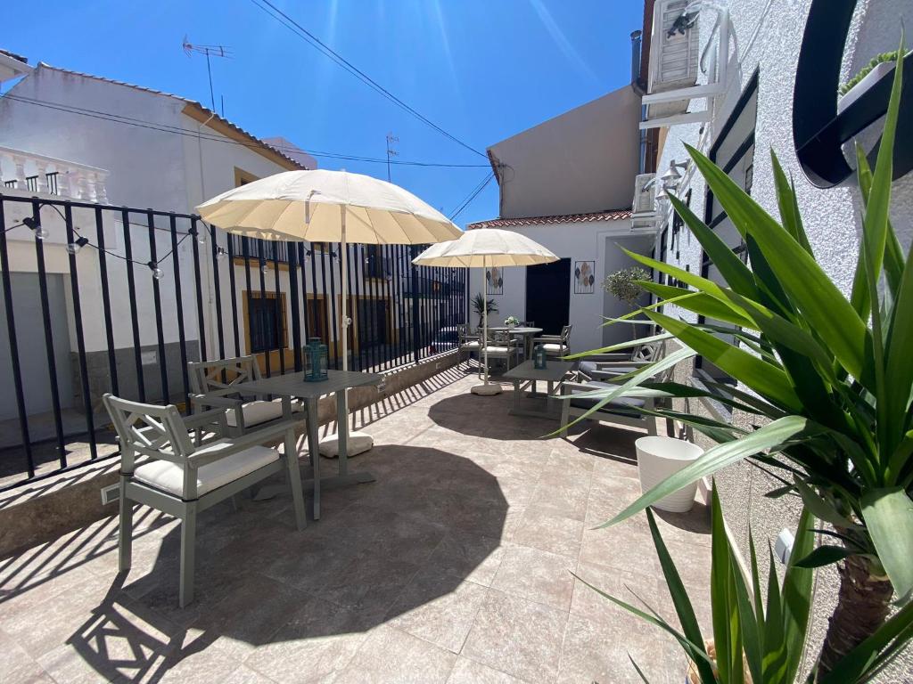 un patio con mesas y sombrillas en un edificio en Jerez Hostel, en Jerez de los Caballeros