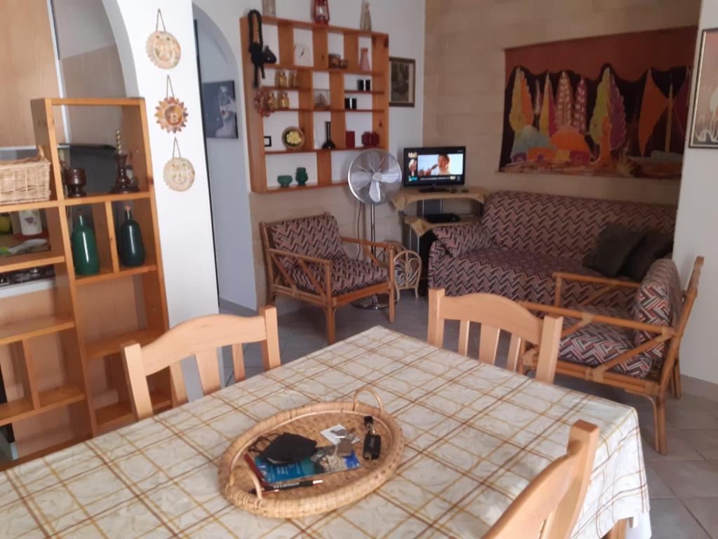 a living room with a table and chairs and a couch at Casa Vacanza Rita in Marina di Pescoluse