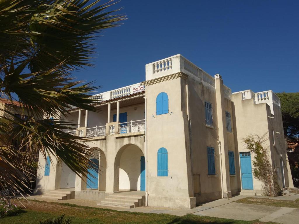un gran edificio blanco con ventanas azules y una palmera en Studio Les Nautiles by Interhome, en La Madrague