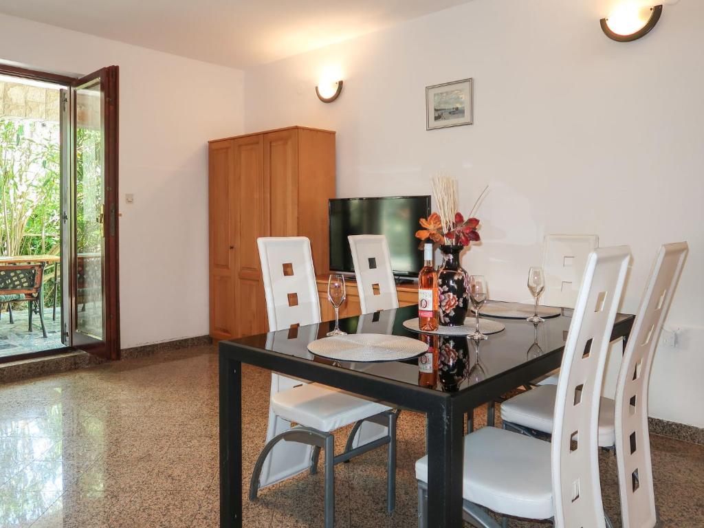 jadalnia z czarnym stołem i białymi krzesłami w obiekcie Holiday Home Maravic-1 by Interhome w mieście Dobrinj