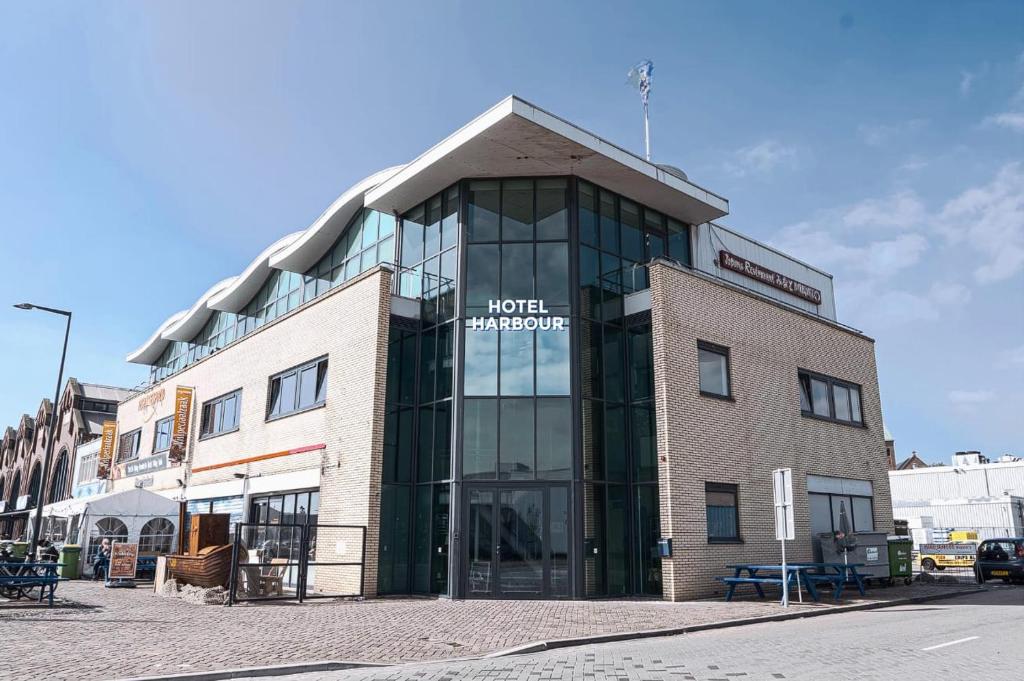 un edificio con un cartel en la parte delantera en Harbour Hotel IJmuiden, en IJmuiden