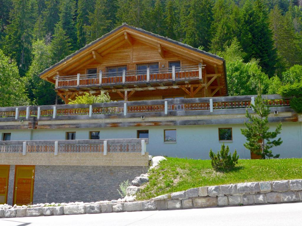 a large wooden house with a balcony on top of it at Chalet Chalet Astoria by Interhome in Crans-Montana