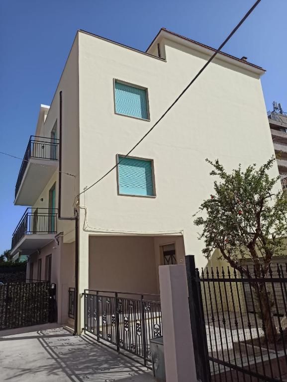 a white house with blue windows and a fence at Casa Vacanza Gabriella in Montesilvano