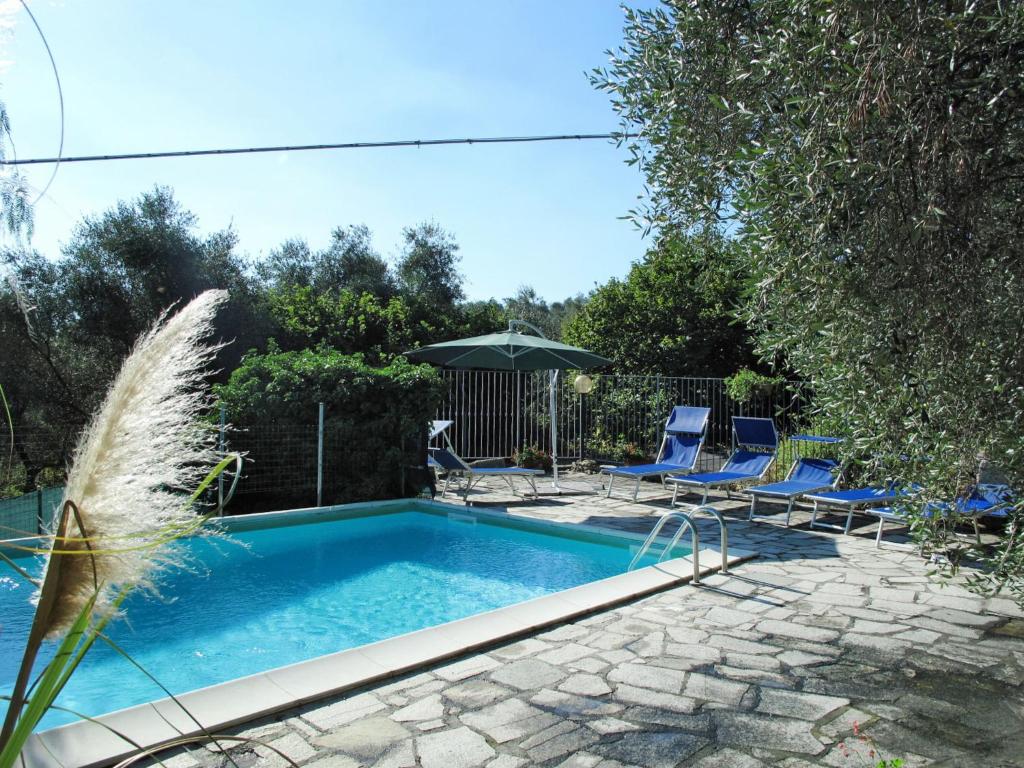 una piscina con 2 sillas y una sombrilla en Apartment Giulia - DOL236 by Interhome, en Dolcedo