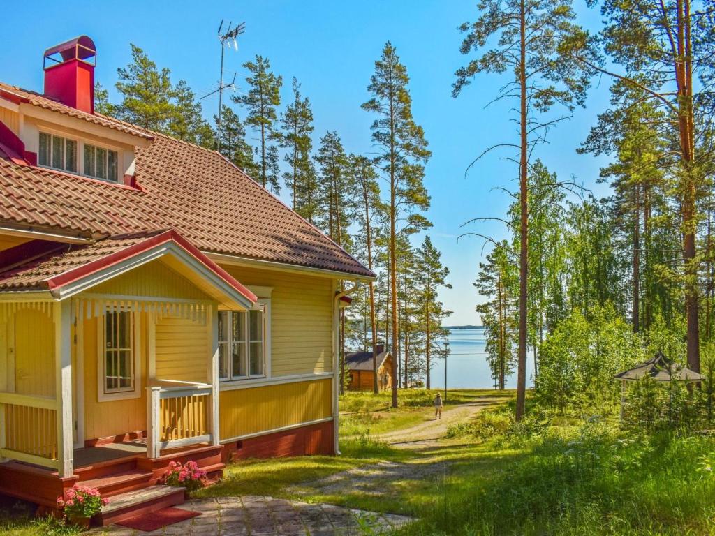 une maison jaune avec vue sur l'eau dans l'établissement Holiday Home Villa kukkapää by Interhome, à Sulkava