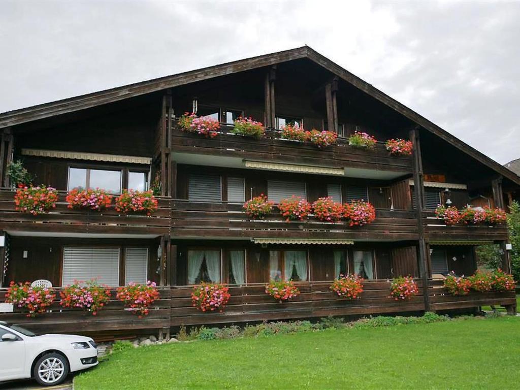 a house with flower boxes on the front of it at Apartment Mösli - Zimmerli by Interhome in Zweisimmen