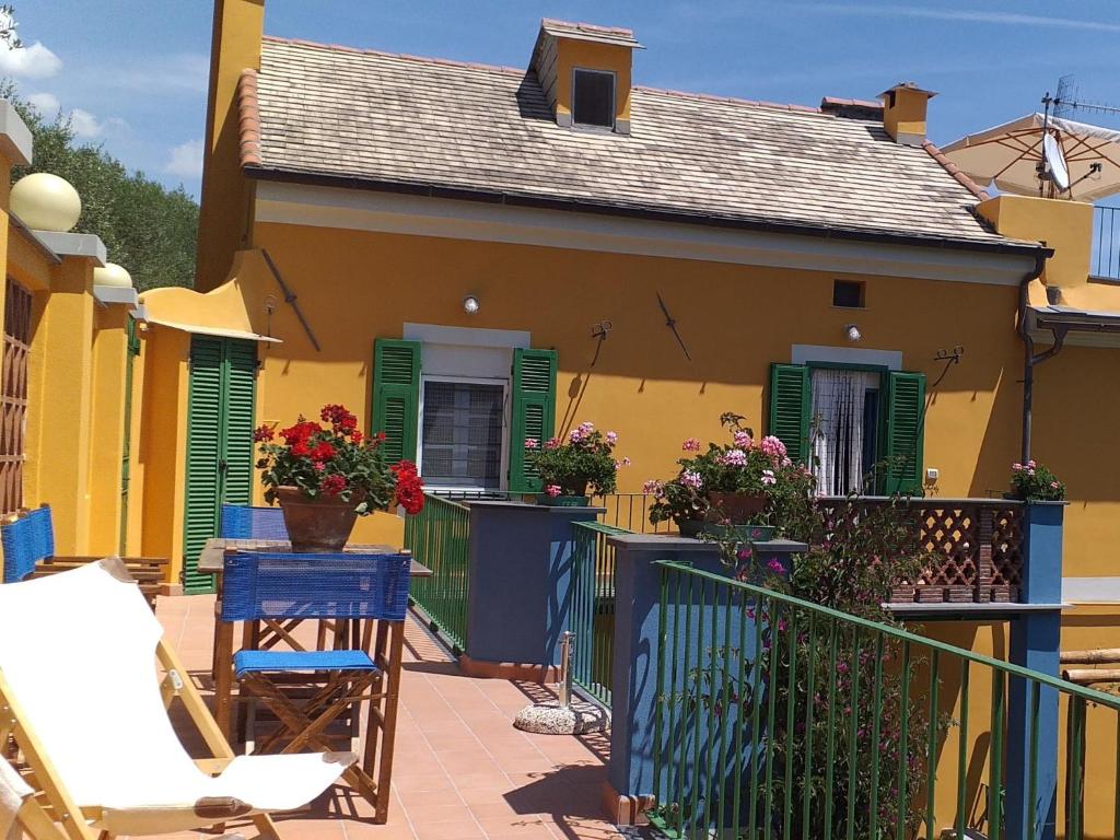a yellow house with green shutters and a balcony at Apartment Casa del Poggio by Interhome in Brasi