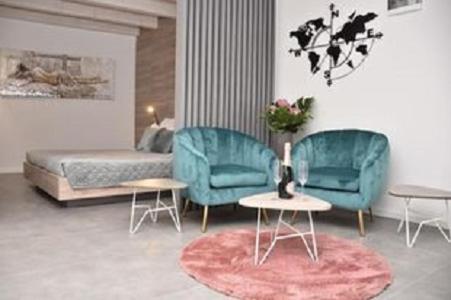 uma sala de estar com duas cadeiras azuis e uma cama em Apartments Hidden paradise Rovinj em Rovinj