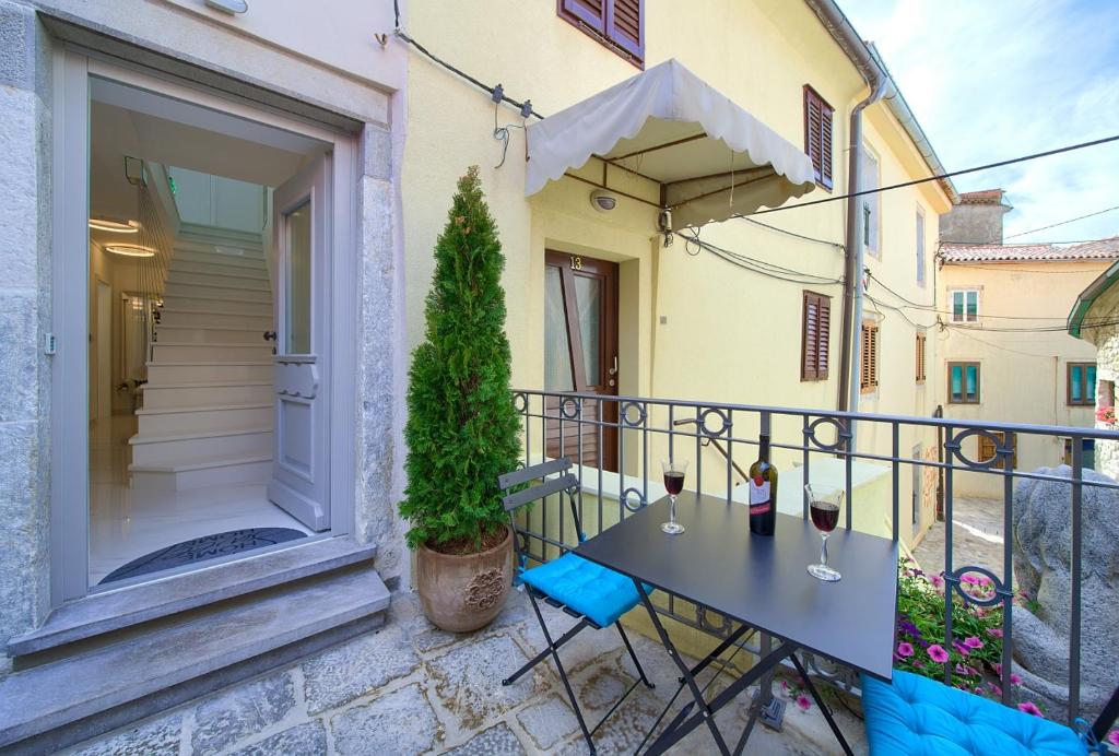 balkon ze stołem i kieliszkami do wina w obiekcie Casa Aurelia - Aurelia Design w Krku
