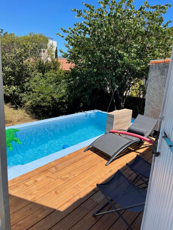 een terras met 2 stoelen en een zwembad bij Les milles feuilles in Marseille