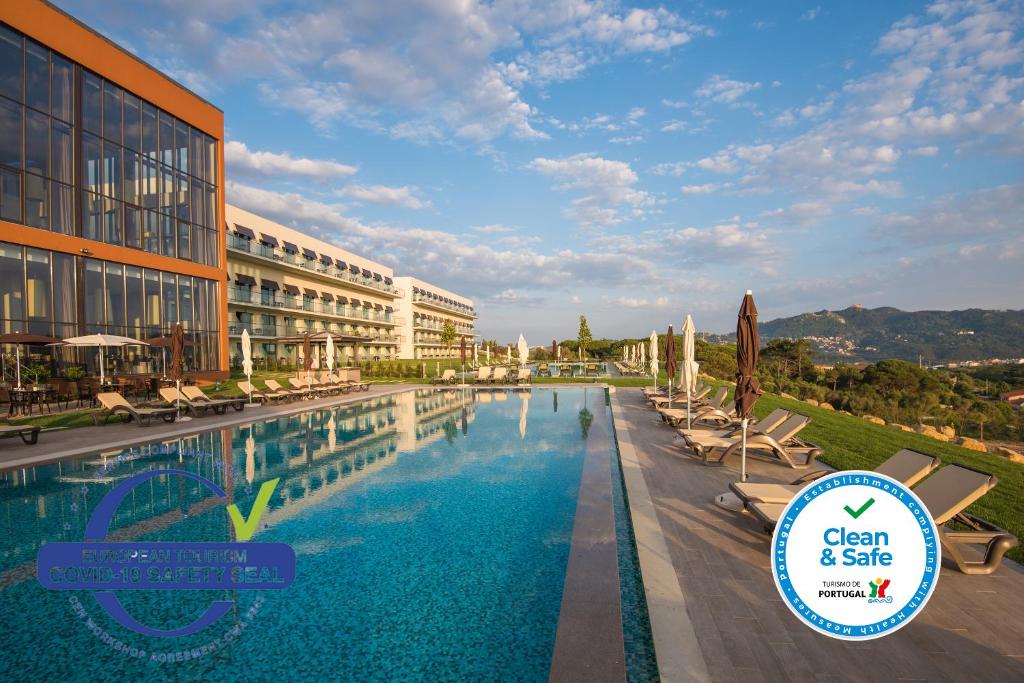 a pool at a resort with chairs and a building at Vila Gale Sintra in Sintra