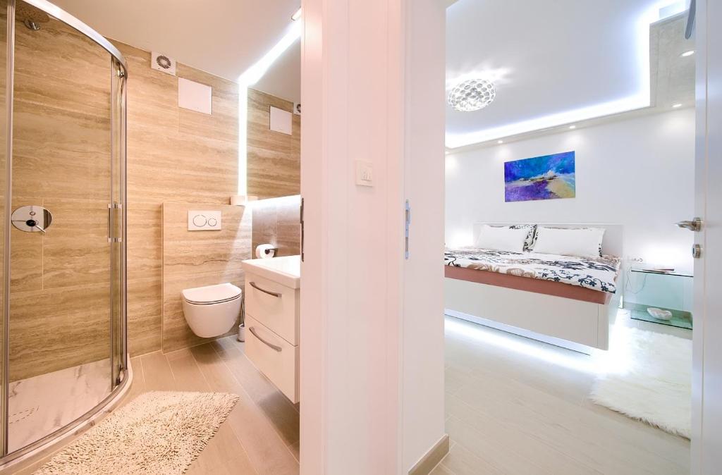 een badkamer met een douche, een toilet en een bed bij Casa Aurelia - Mali Tone in Krk