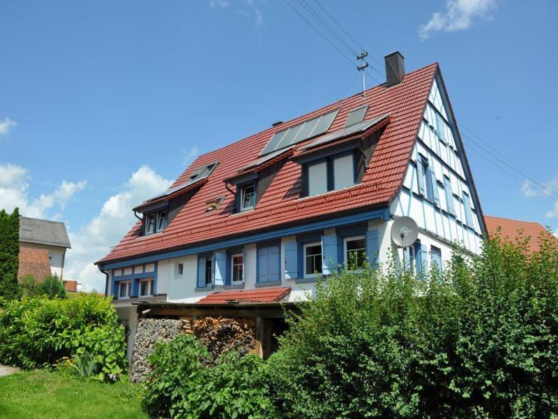 una casa con techo rojo encima en Pension Schwalbennest, en Herdwangen-Schönach